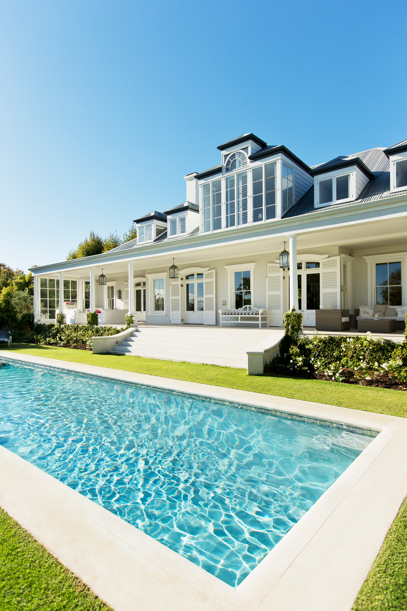 Homeowner relaxing by a crystal-clear pool maintained by Crown and Current Pool Co. in Charlotte NC